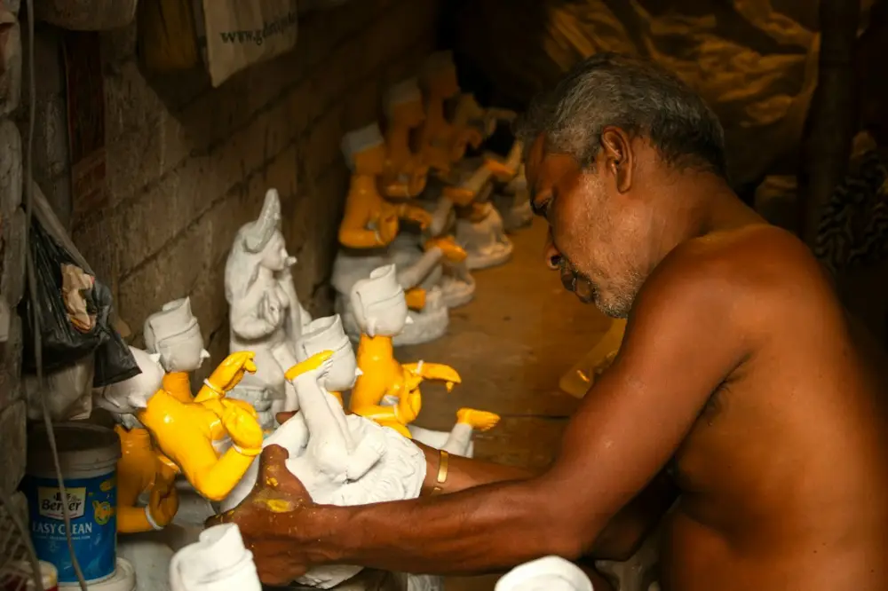Man crafting small statues in a workshop, illustrating local experiences